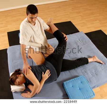 man therapist stretching female client in massage