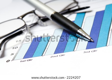 annual report with glasses and pen on graph