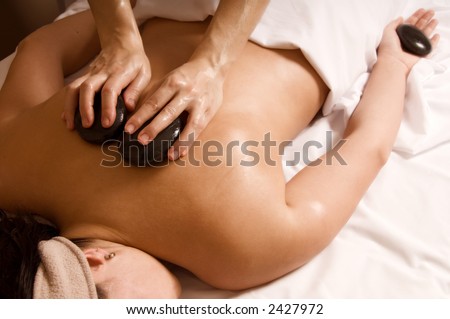 Therapist giving a hot stone massage to client