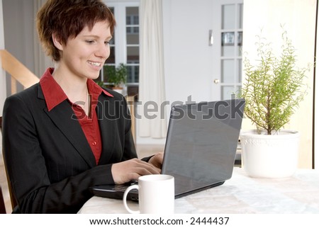 woman in a black suit on her laptop at home