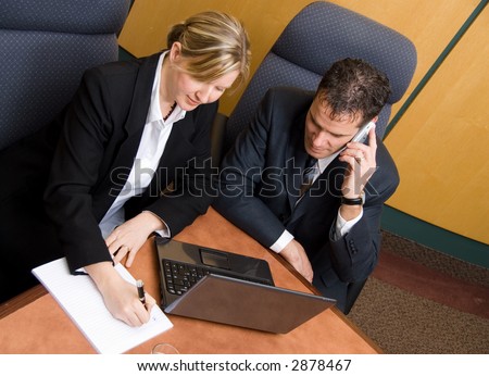 business colleagues in a board room with a laptop and phone