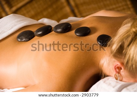 blond woman at a day spa with hot stones