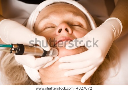 older woman getting electrolysis on he face