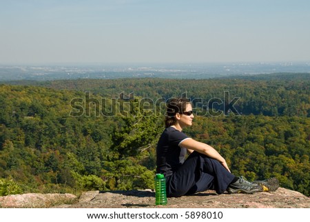 sitting woman on top of a mountain
