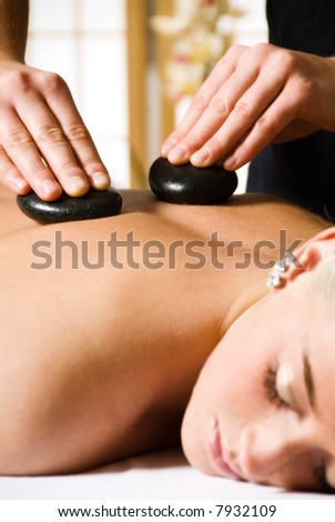 woman getting a hot stone massage at a day spa