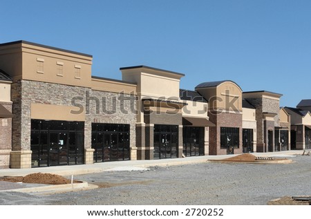 A suburban shopping center under construction, made to appear like a small town street.  Empty storefronts.