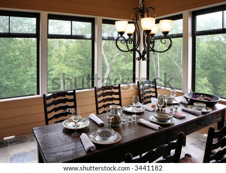 A rustic yet classy outdoor dining setup on a screened porch.