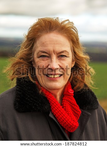 A senior lady, windblown and cold