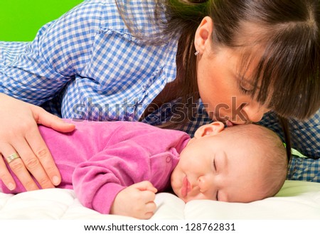 Mother kissing daughter for sweet dreams