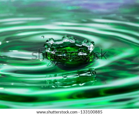 Green water drop falling and make splash