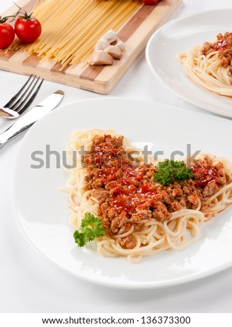 White plate with spaghetti and meat sauce