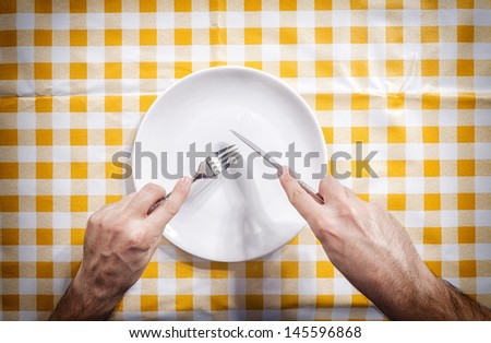 Empty white plate and human hands from above