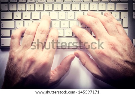 Typing hands on the keyboard from above