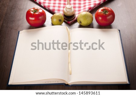 Empty cookbook and organic food on the wooden table