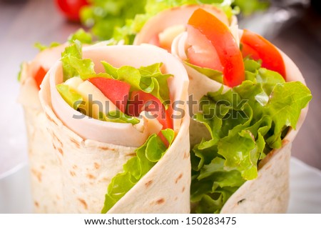 Tasty tortilla sandwich wrap with turkey and vegetables