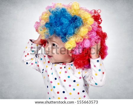 Happy little baby with clown wig on her head