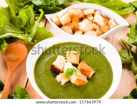 Fresh homemade spinach soup with dried crust in the bowl. Selective focus on the soup