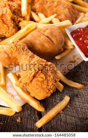 Junk food on the table.Deep fried chicken legs and french fries