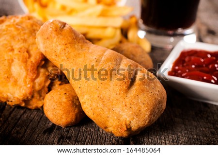 Fried chicken legs with french fries in the background.Selective focus on the front chicken leg
