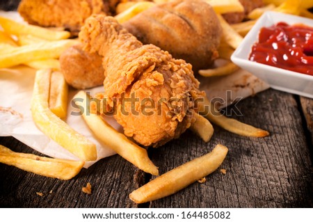 Deep fried chicken leg and french fries on the table