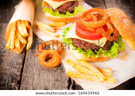 Beef burger with onion rings and french fries.Selective focus on the burger and onion rings