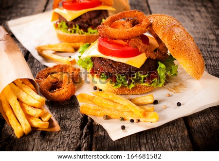 Big burger in bun with onion rings and french fries.Selective focus on the burger