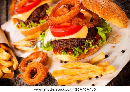 American cuisine with cheeseburger, onion rings and french fries.Selective focus on the cheeseburger