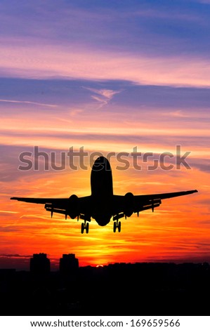 Concept or conceptual black plane, airplane or aircraft silhouette flying over sky at sunset or sunrise background
