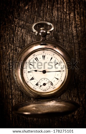Old pocket watch on the wooden background.Selective focus in the middle of watch