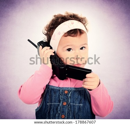 Little child holding old fashion cell phone