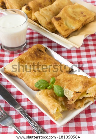 Fried pastry and glass of yogurt.Selective focus on the front pastry in plate