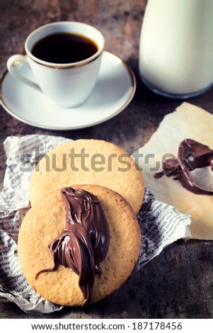 Selective focus on the front round cookie with melting chocolate on wooden table