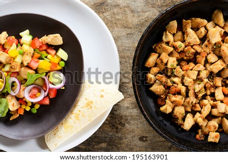 Fresh chicken meat in the salad and pan from above