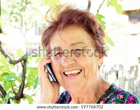 Old lady using mobile phone and have smile on her face