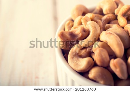 Selective focus on left cashew nut in cup.Blank space on the left side