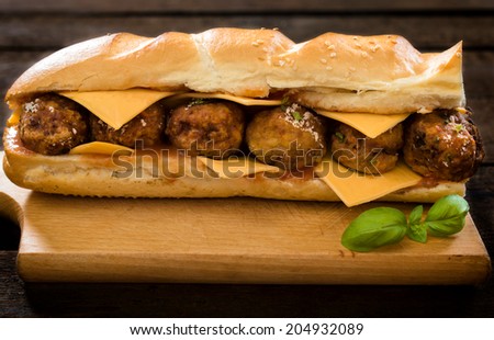 Big and juicy meatball sandwich on the wooden background