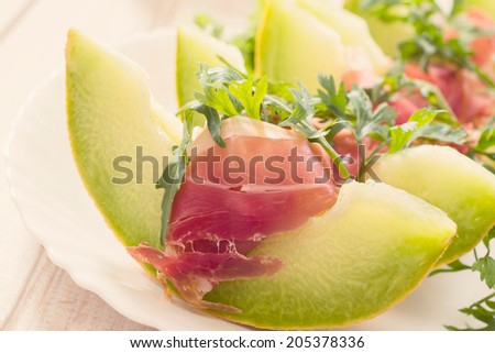 Italian prosciatto and green melon in the plate.Selective focus on the front slice of melon