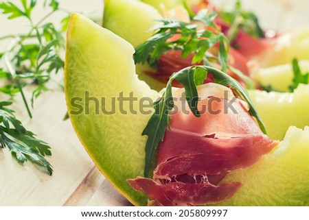 Italian proscutto and green melon in the plate.Selective focus on the front slice of melon