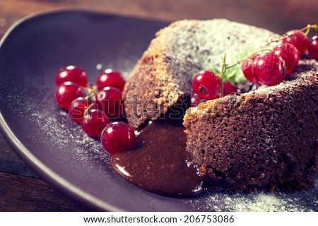 Red currants and lava cake stuffed with melted chocolate,selective focus