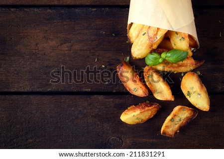 Baked potatoes on the wooden table from above with blank space on left side
