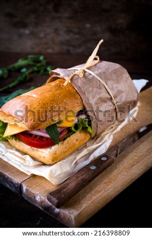 Stuffed sandwich with ham and cheese on the wooden board,selective focus