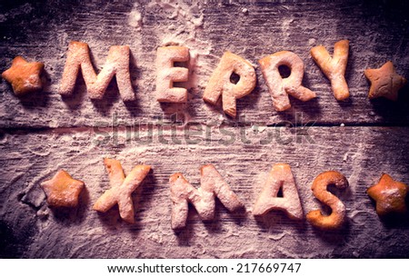 Merry Xmas text with cookies in the wooden background from above