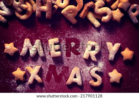Merry Xmas text with cookies in the red background from above