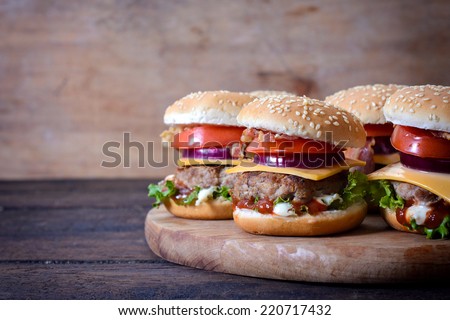 Juicy beef burgers on wooden background and the blank space on left side