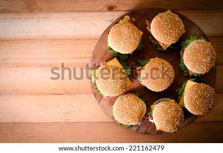 Group of beef burgers on the wooden background,from above and selective focus.Blank space on the left side