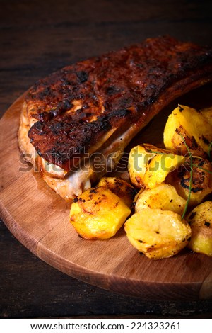 Baked potatoes and beef ribs in bbq sauce on wooden background,selective focus