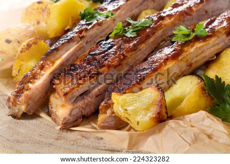 Sliced beef ribs in bbq sauce and baked potatoes,selective focus