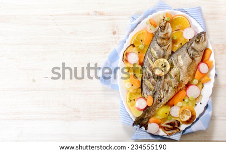 Prepared bass fish on white wooden background with blank space