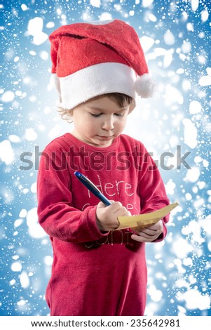 Little child holding Christmas wish list in his hands