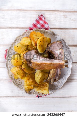 Baked lamb ribs with potatoes in the plate
